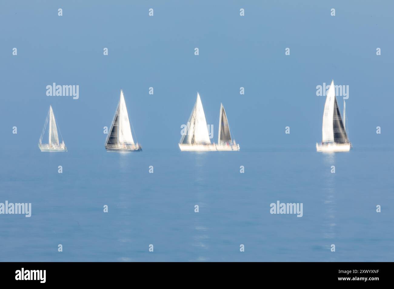 Segelboote fahren am 14. August 2024 über die Raritan Bay in der Gegend zwischen Staten Island und New Jersey. Eine lange Belichtung wurde verwendet, um Bewegungen aufzunehmen. Stockfoto