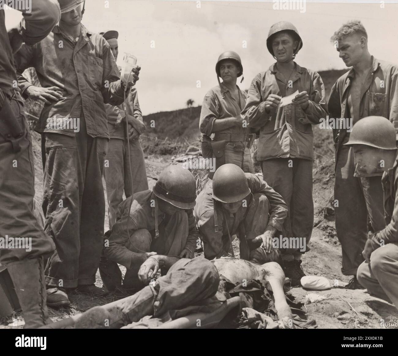 2. Weltkrieg: Schlacht von Guam (1944). 21. Juli bis 10. August 1944 bei Guam verwundet. Dieser Marine, der bei einem Angriff auf japanische Stellungen auf Sugar Bluff, Guam, am Kopf und in der Brust verletzt wurde, erhält Blutplasma, um Schock und Blutverlust zu bekämpfen. Stockfoto