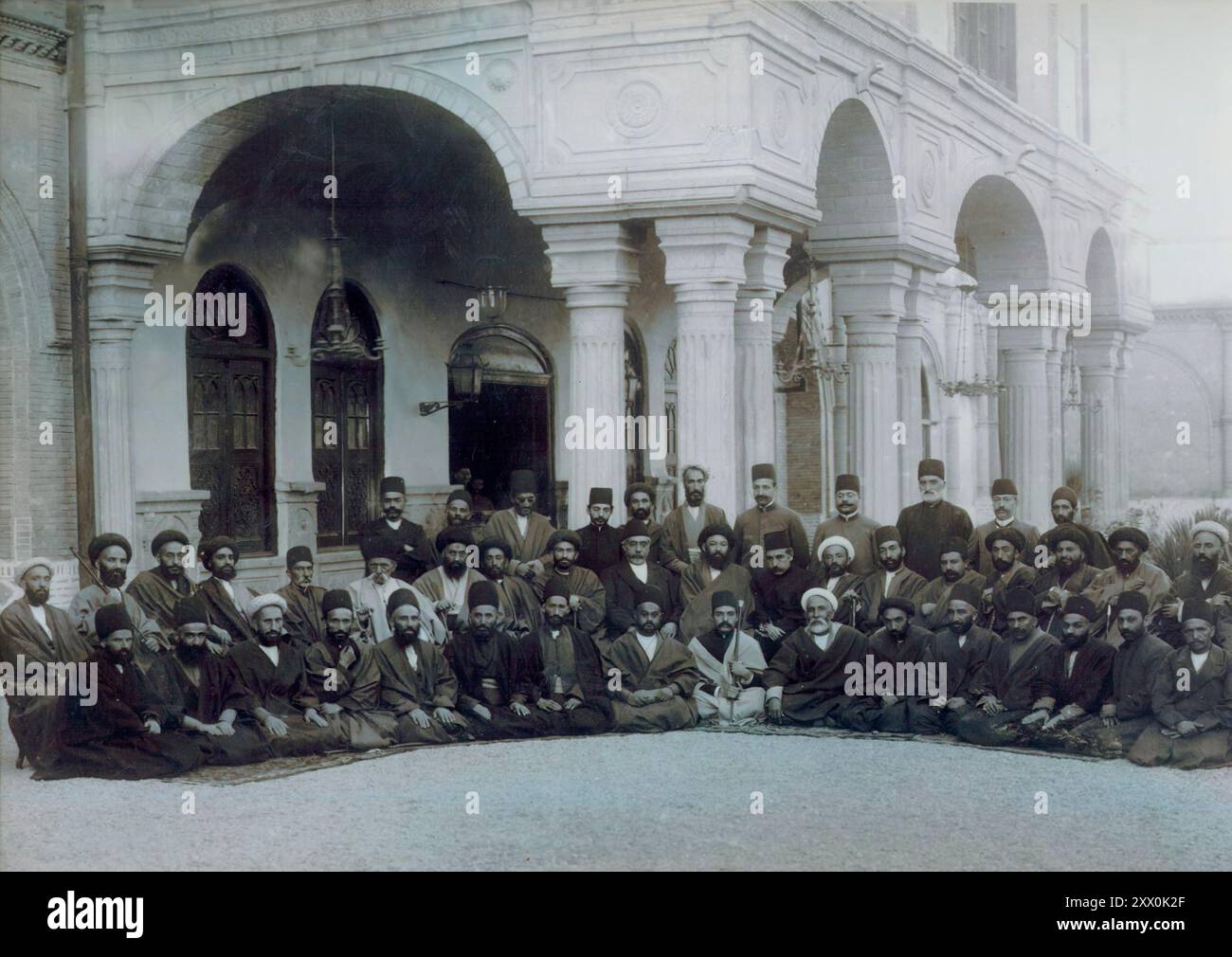 Vintage-Foto von Vertretern des ersten iranischen Parlaments. Teheran, 1906 dieses Foto zeigt die Vertreter der ersten iranischen Majles (parlament) vor der Militärakademie, die als erstes parlamentsgebäude diente. In den 1870er Jahren und Anfang des 20. Jahrhunderts kamen führende politische Persönlichkeiten im Iran zu dem Schluss, dass die einzige Möglichkeit, das Land vor Regierungskorruption und fremder Manipulation zu retten, darin bestand, einen schriftlichen Gesetzbuch zu erstellen, eine Haltung, die den Grundstein für die iranische Verfassungsrevolution von 1905 legte. Die Bewegung für eine Verfassung trug während der Regierungszeit von Muz Früchte Stockfoto