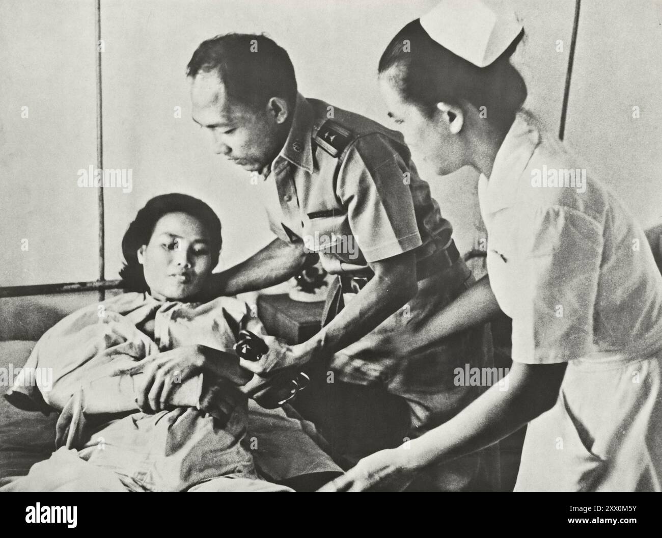 Vietnamkrieg. Der Gemeinsame Kampf: Asiatische Streitkräfte Unterstützen Südvietnamesische Truppen. Philippinischer Arzt behandelt zivile Opfer des Viet Cong-Angriffs. Ca. 1965-1973 Stockfoto