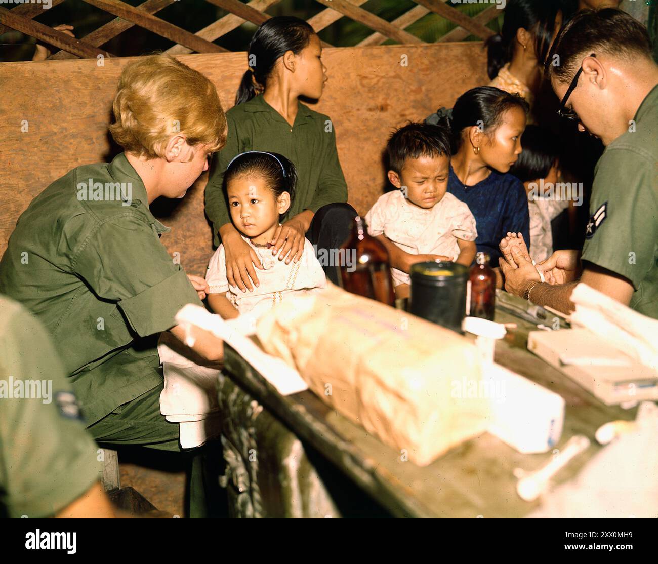 Vietnamkrieg. Leutnant Kathleen M. Sullivan behandelt ein vietnamesisches Kind während der Operation MED CAP, einem zivilen Aktionsprogramm der US Air Force, in dem ein Team von Ärzten, Krankenschwestern und Helfern in vietnamesische Dörfer reist, Kranke behandelt und Dorfbewohnern die Grundlagen der sanitären und sauberen Einrichtungen vermittelt. 1967 Stockfoto