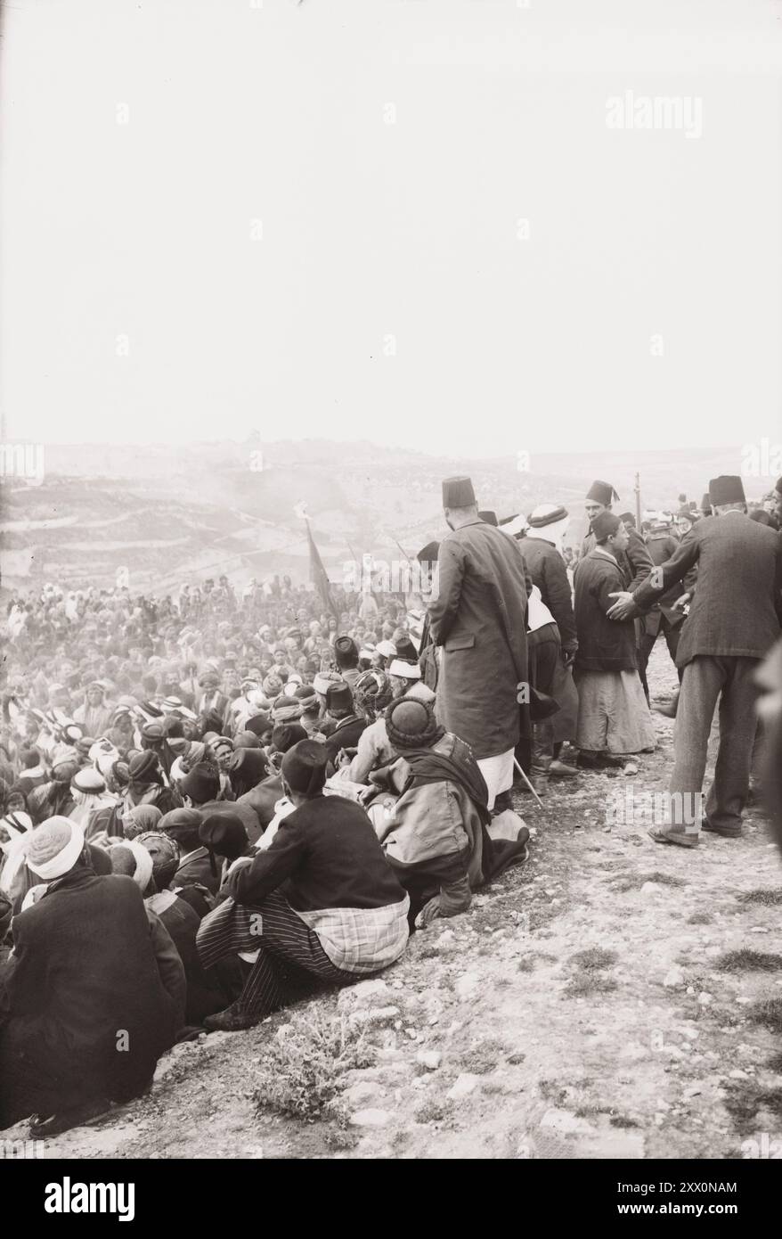 Das Leben in Palästina im frühen 20. Jahrhundert. Schwerttanz in der Prozession (Nebi Musa Prozession). Das Historische Palästina. Osmanisches Reich. 1900-1920 Nabi Musa („der Prophet Moses“, auch übersetzt als Nebi Musa) ist in erster Linie eine muslimische heilige Stätte in der Nähe von Jericho in Palästina, wo eine lokale muslimische Tradition das Grab von Moses (im Islam Musa genannt) platziert. Das Gelände befindet sich auf einer Moschee, in der sich das angebliche Grab befindet. Früher war es Schauplatz eines gleichnamigen siebentägigen religiösen Festivals, das jährlich von palästinensischen Muslimen gefeiert wurde, beginnend am Freitag vor Karfreitag im Ort Stockfoto