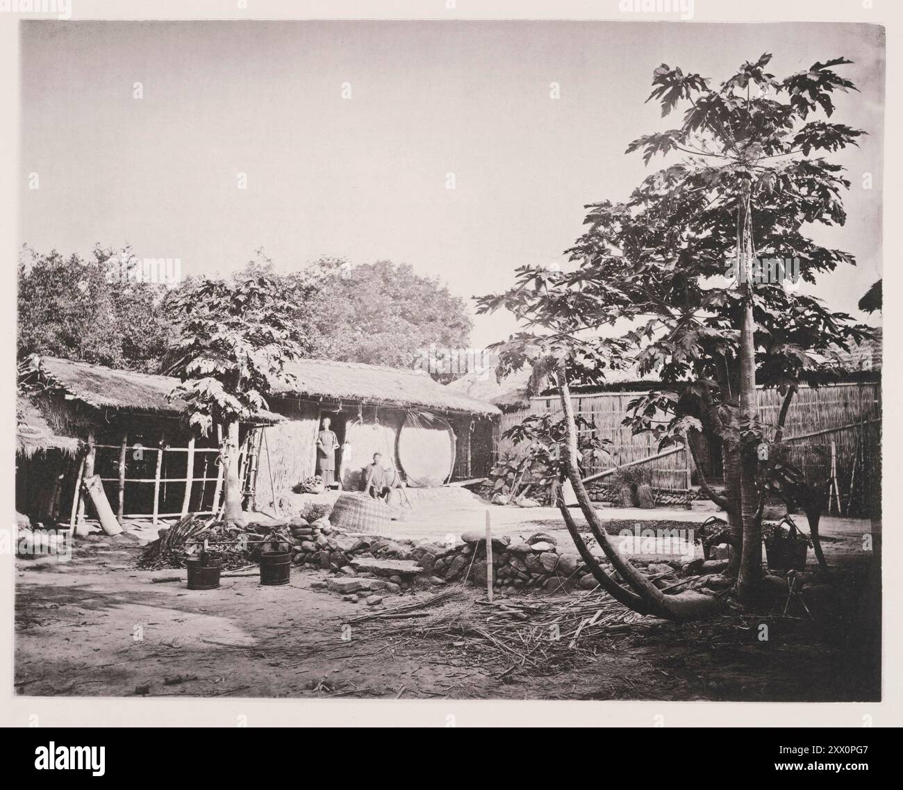 Vintage-Foto von der Insel Formosa. Taiwanesische Aborigines. Eine Pepohoan-Wohnung. Illustrationen von Qing China, 1875 die Häuser der Pepohoans sind tolerierbar sauber, gut ausgestattet und komfortabel und zeigen eine auffallende einheitliche Gestaltung in den defferenten Siedlungen auf der ganzen Insel. Die gesamte Wohnung besteht aus drei Seiten eines Quadrats, von dem der Teil im hinteren Teil von der Familie besetzt ist, während die beiden Flügel ausnahmslos für die Unterbringung von Rindern, Schweinen und Geflügel genutzt werden. Stockfoto