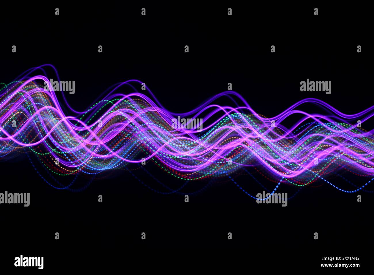 Lichtmalerei Fotografie - wirbelnde Wellen von neonrosa Licht vor schwarzem Hintergrund Stockfoto