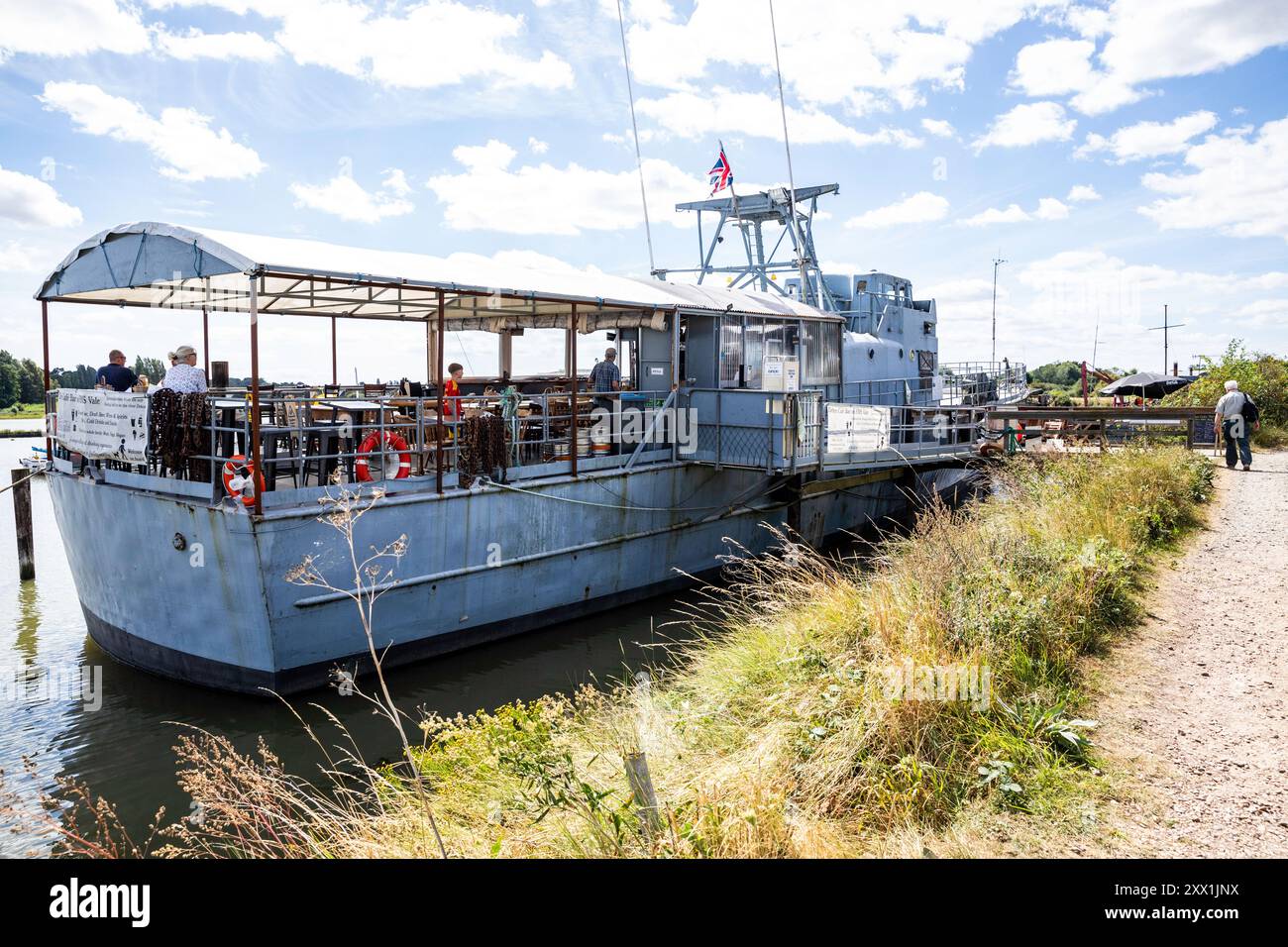 Melton, Suffolk, 21. August 2024, die Leute waren in der Deben Cafe Bar auf der HMS Vale in der Sonne, Melton, und genossen die wunderschöne Aussicht über den Fluss Deben in Suffolk. Während der Sommerferien liegen viele Boote entlang des Flusses vor. Die Temperatur beträgt zu dieser Jahreszeit angenehme 21 °C. Quelle: Keith Larby/Alamy Live News Stockfoto