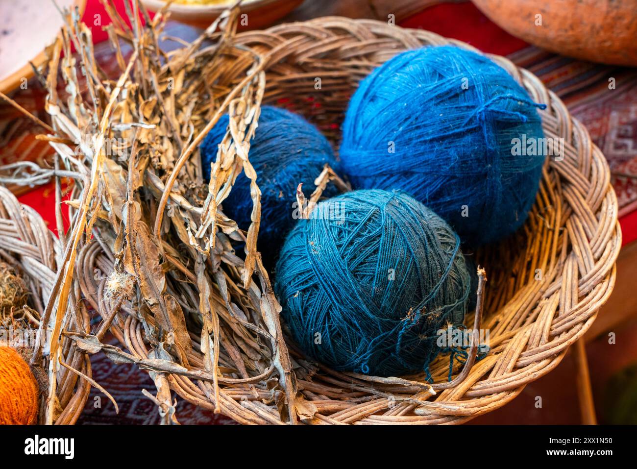 Blaue Wollkugeln und getrocknete Pflanzen als Naturfarbstoff, Chinchero, Heiliges Tal, Provinz Urubamba, Region Cusco (Cuzco), Peru, Südamerika Stockfoto