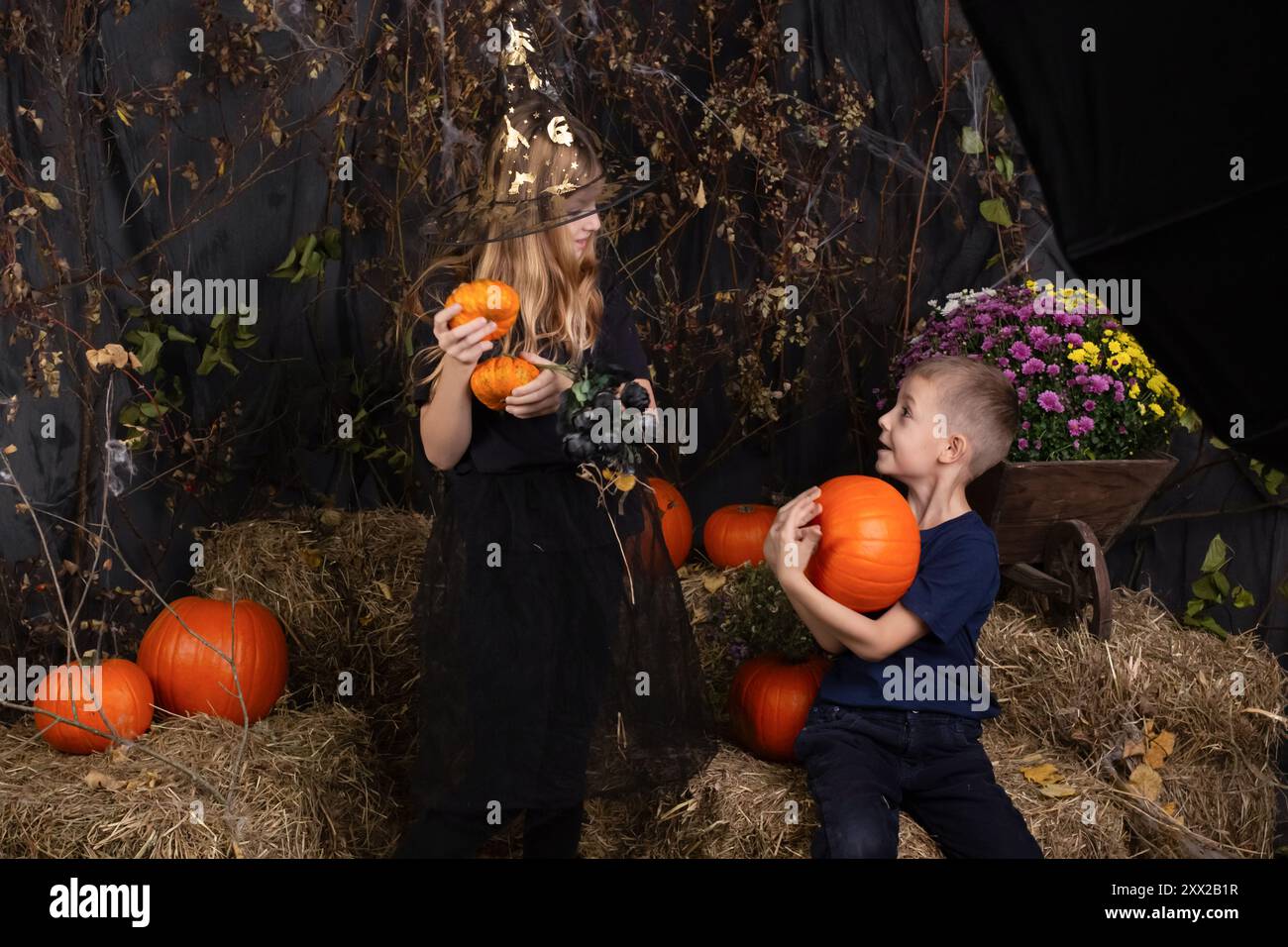 Glückliche Bruder und Schwester an Halloween. Lustige Kinder in Karnevalskostümen drinnen. Kinder, die sich auf Halloween vorbereiten Stockfoto