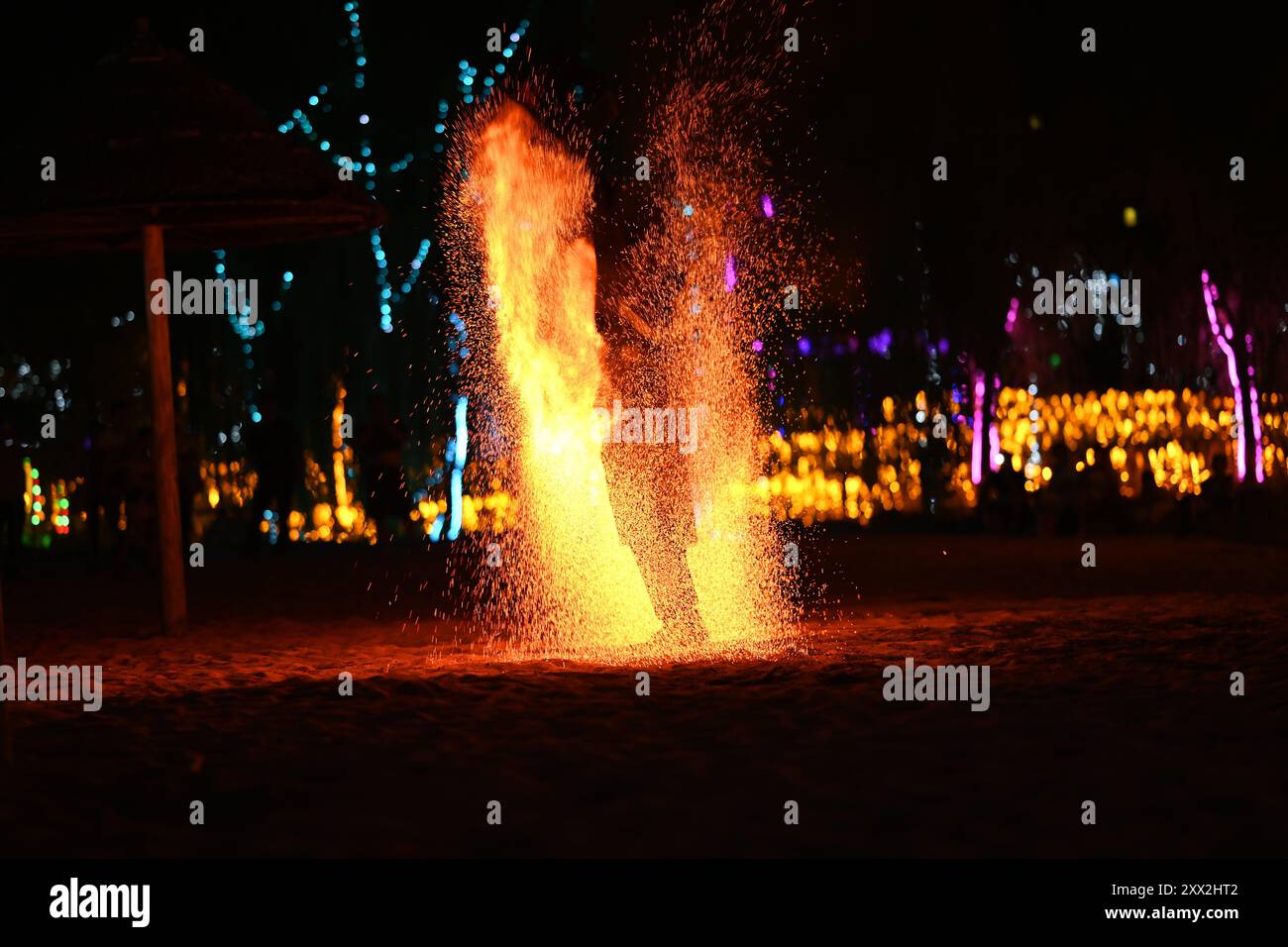 Dieses Foto fängt einen dynamischen und visuell beeindruckenden Moment eines Feuerführers in Aktion ein. Die leuchtenden Farben der Flammen. Stockfoto