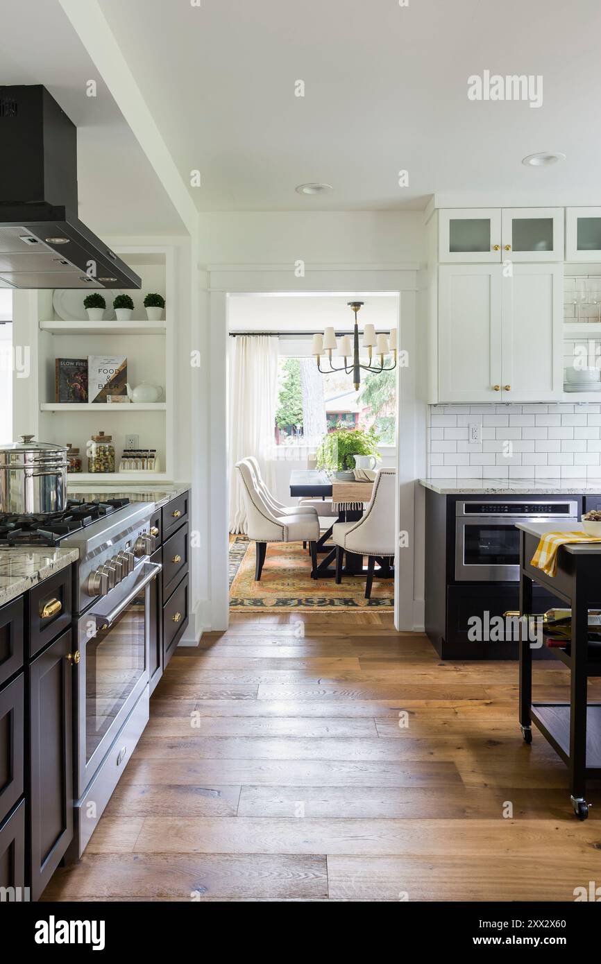 Blick durch die stilvolle schwarz-weiße Küche in das Esszimmer Stockfoto