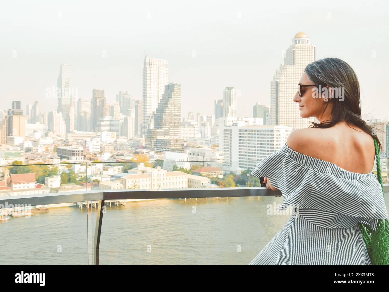 Bangkok, Thailand - 11. februar, 2024: kaukasierin Touristen Genießen Sie Shopping Mall Blick aus berühmten Aussichtspunkt über den Fluss an sonnigen heißen Tagen im Südosten Stockfoto