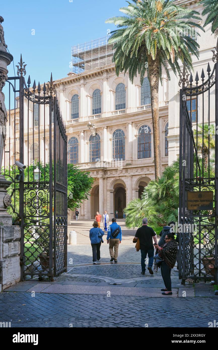 Eintritt zur Barberini Palacepalm in Rom, Italien. Besucher gehen durch die kunstvollen Tore in den historischen barocken Schlosshof Stockfoto