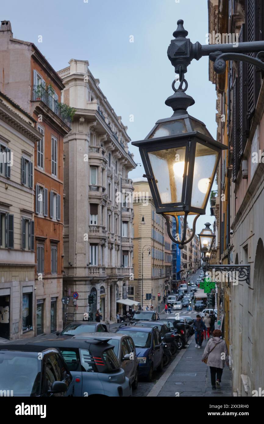 Charmante Straßenszene in Rom, Italien, mit Vintage-Laternen, die eine klassische italienische Straße beleuchten. Das Wesen des Alltags einfangen Stockfoto