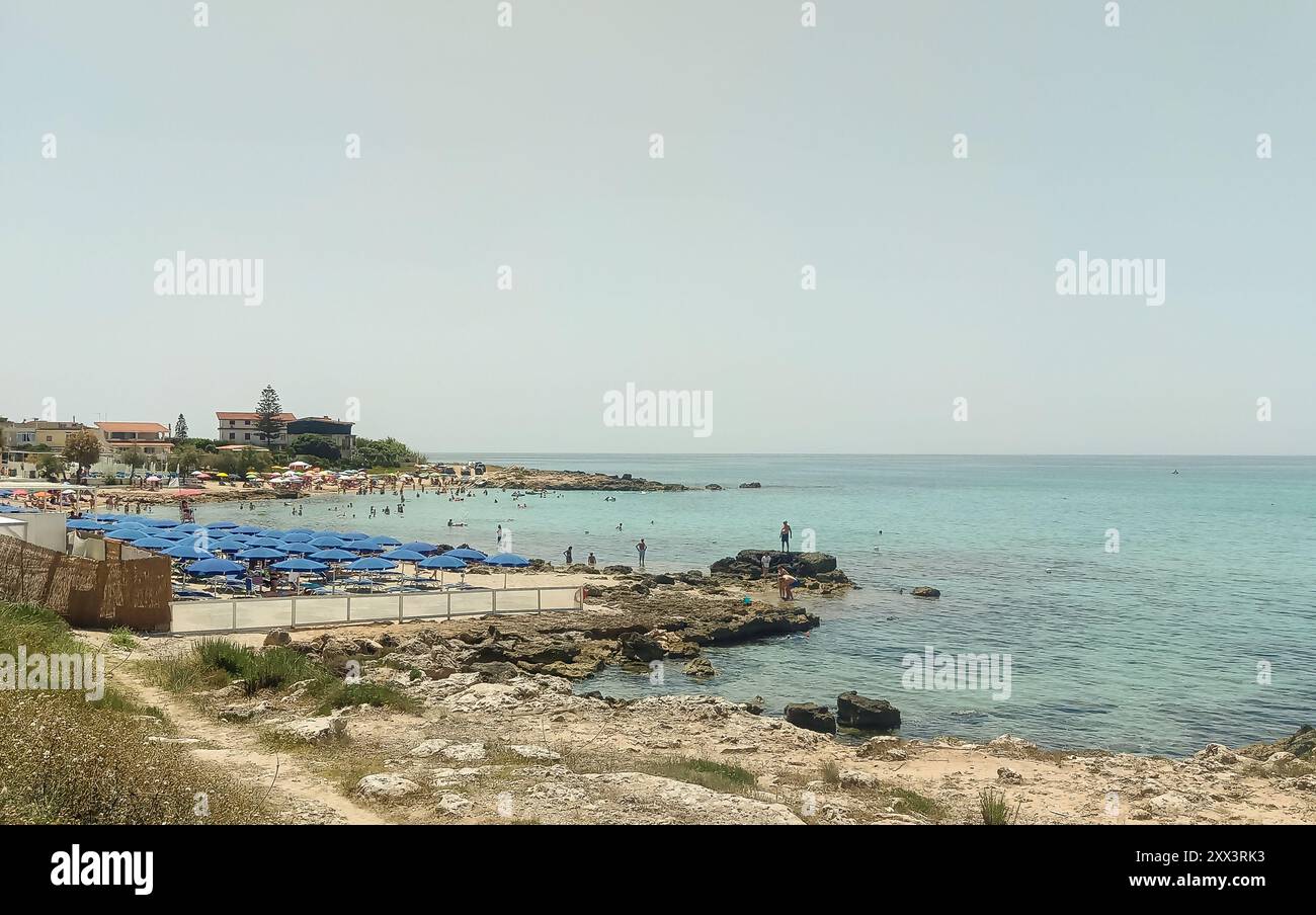 Strandresort mit offenen Sonnenschirmen vor dem ruhigen und kristallklaren Meer Stockfoto