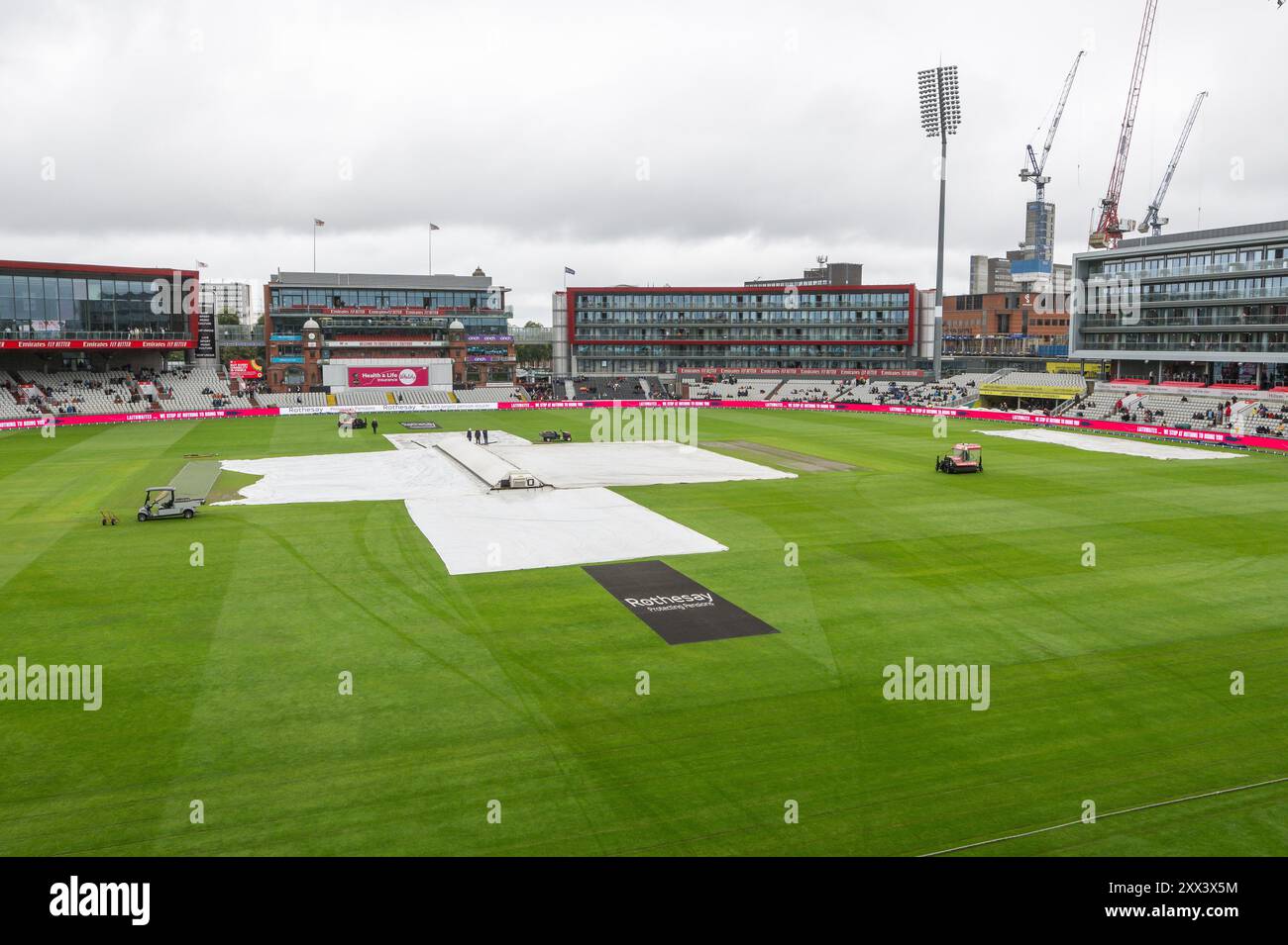 Regenbezüge werden entfernt, wenn der Regen vor dem 1. Rothesay Test Match Day 2 in Old Trafford, Manchester, Großbritannien, 22. August 2024 stoppt (Foto: Craig Thomas/News Images) Stockfoto