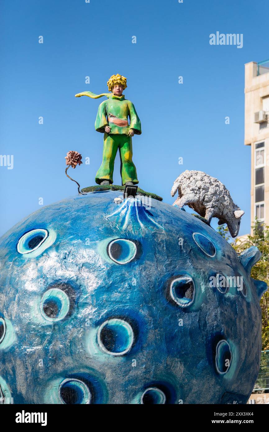 Statue des kleinen Prinzen mit seiner Rose und seinen Schafen auf einem blauen Planeten in einem Kreisverkehr in Eilat. Eine Hommage an das klassische Buch Antoine de Saint-Exupery Stockfoto