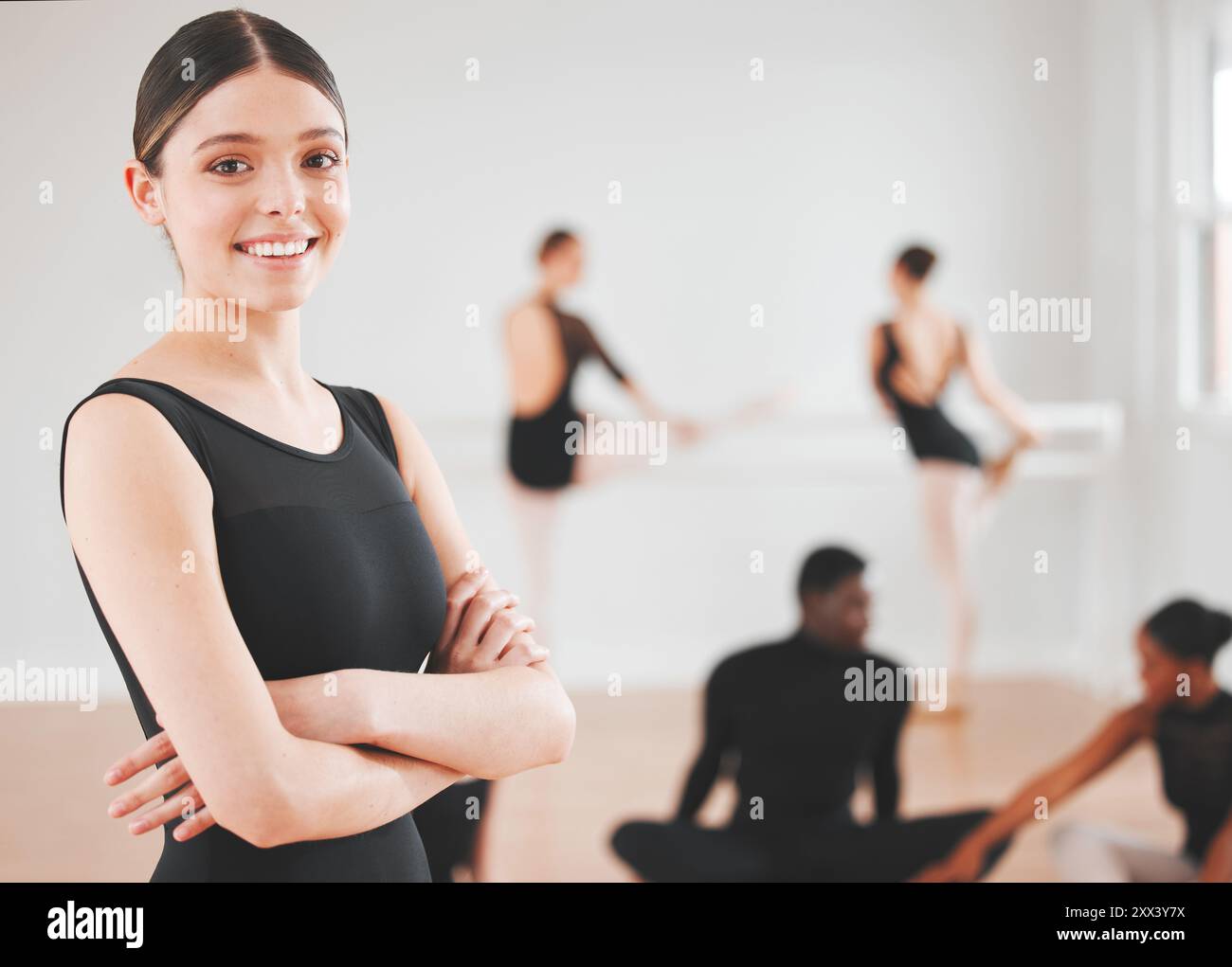 Ballett, Mädchen und Porträt mit überkreuzten Armen im Tanzstudio für Performance-Kunst, Unterricht und Selbstvertrauen. Ballerina, Lächeln und eine Person mit Stolz Stockfoto
