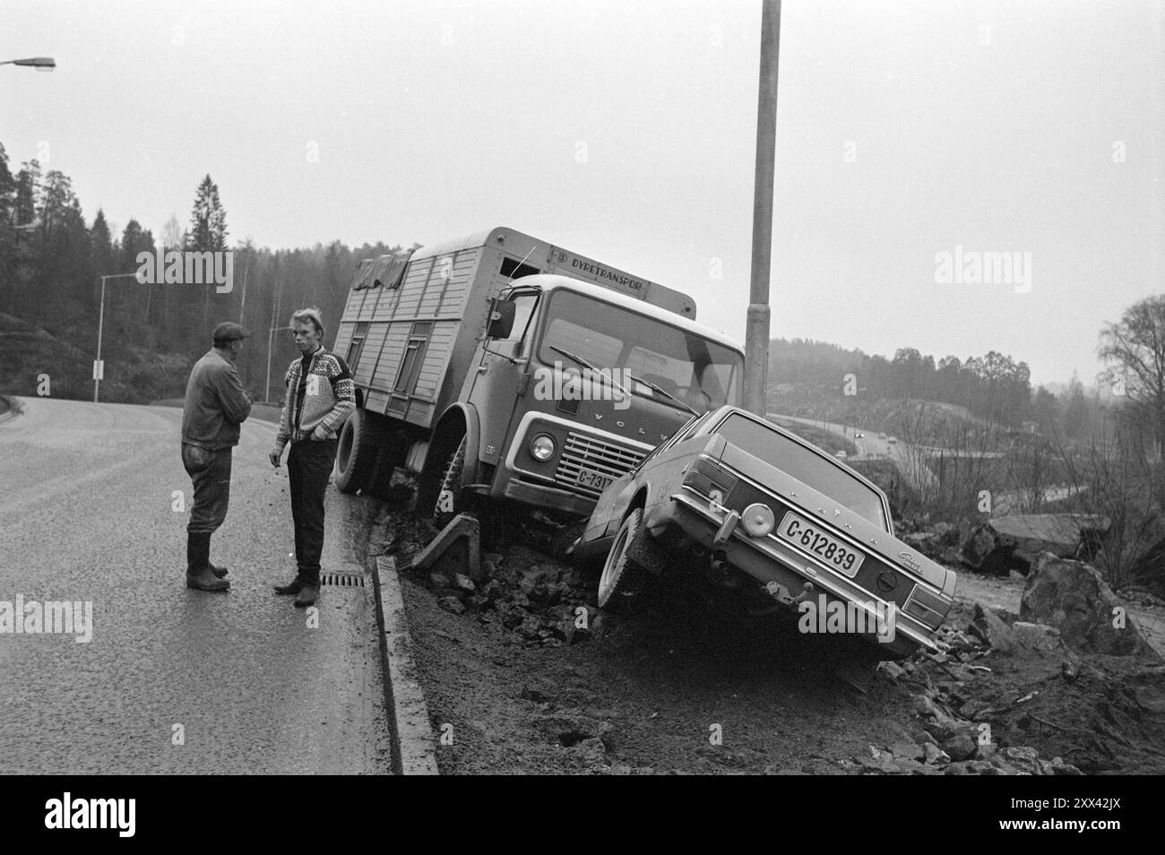 Aktuell 49-5-1970: Tiertodfalle. Mosseveien wurde zur Blutstraße im Volksmund. Die Autofahrer seufzten erleichtert, als eine neue Autobahn die alten engen Kurven entlastete. Aber dann kamen die Unfallberichte. Die übliche Unfallstelle auf der neuen Straße. Ein Bus fuhr vor kurzem hier runter und ein kleiner Junge wurde getötet. Als unser Fotograf sich hier aufstellte, um Fotos zu machen, musste er nicht lange auf den ersten Unfall warten. Dieses Mal war es ein Pkw, der während eines Überholversuchs in einem Anhänger steckte (t. h.). Lebensbedrohliche Situationen treten täglich auf. In Mo Stockfoto