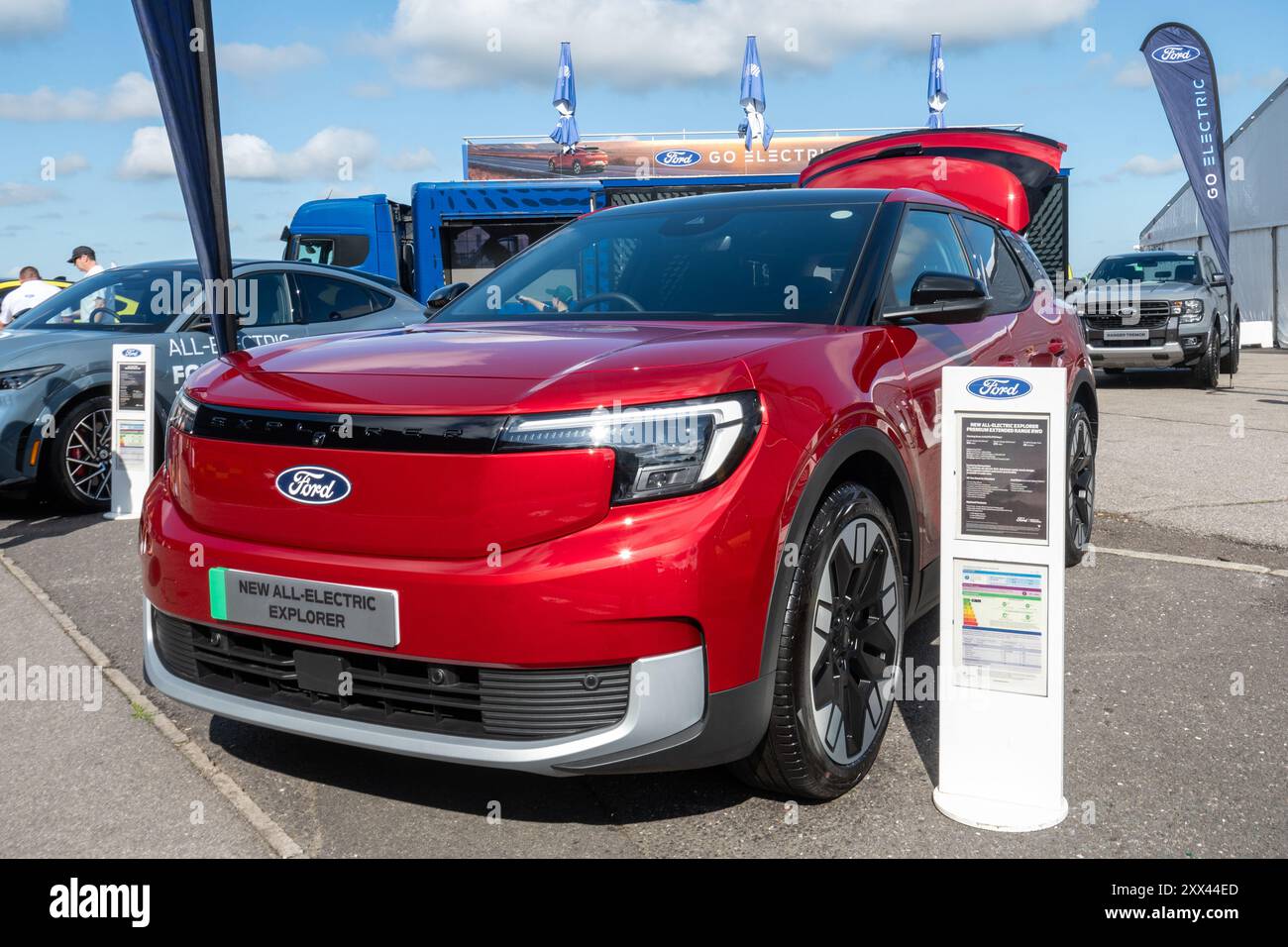 British Motor Show 2024, in Farnborough, Hampshire, England, Vereinigtes Königreich vom 15. bis 18. August 2024. Tag 2 der jährlichen Veranstaltung im Farnborough International Exhibition Centre. Ein roter vollelektrischer Ford Explorer SUV-Wagen auf dem Display. Stockfoto