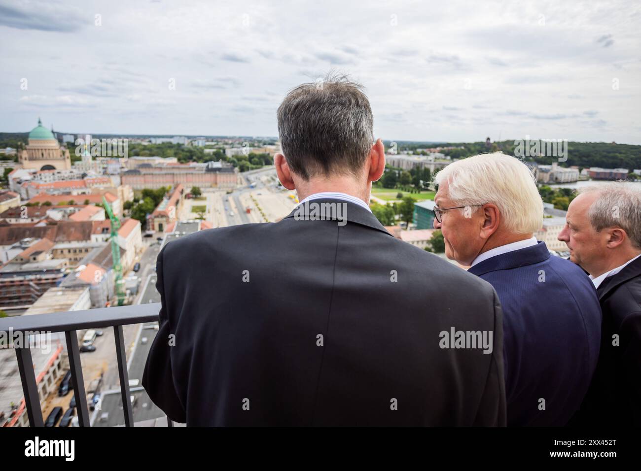 22. August 2024, Brandenburg, Potsdam: Bundespräsident Frank-Walter Steinmeier (M), Schirmherr des Wiederaufbauprojekts, Peter Leinemann (l), Vorsitzender der Stiftung Garnisonskirche Potsdam, und Christian Stäblein (r), Bischof der Evangelischen Kirche Berlin-Brandenburg-Schlesischen Oberlausitz, besuchen die Aussichtsplattform auf dem Turm der Garnisonskirche Potsdam. Der wiederaufgebaute Turm der umstrittenen Garrison Church wurde mit einer Zeremonie wieder eröffnet. Die Militärkirche von 1735 wurde während des Zweiten Weltkriegs verbrannt und die Überreste wurden 1968 gesprengt. Foto: Christoph Soeder/dpa Stockfoto