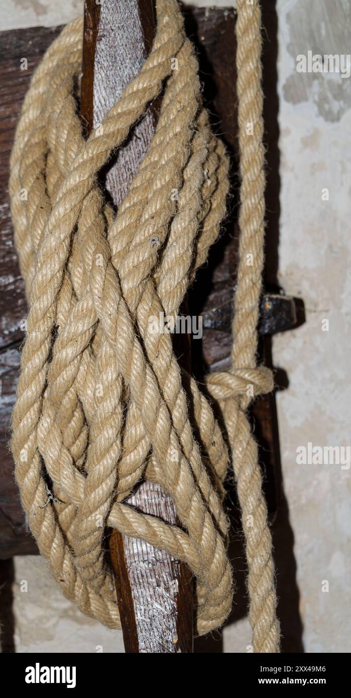 Ein Seil, das in acht Figuren um eine Wandklammer gebunden ist, um schwere Geräte zu sichern Stockfoto