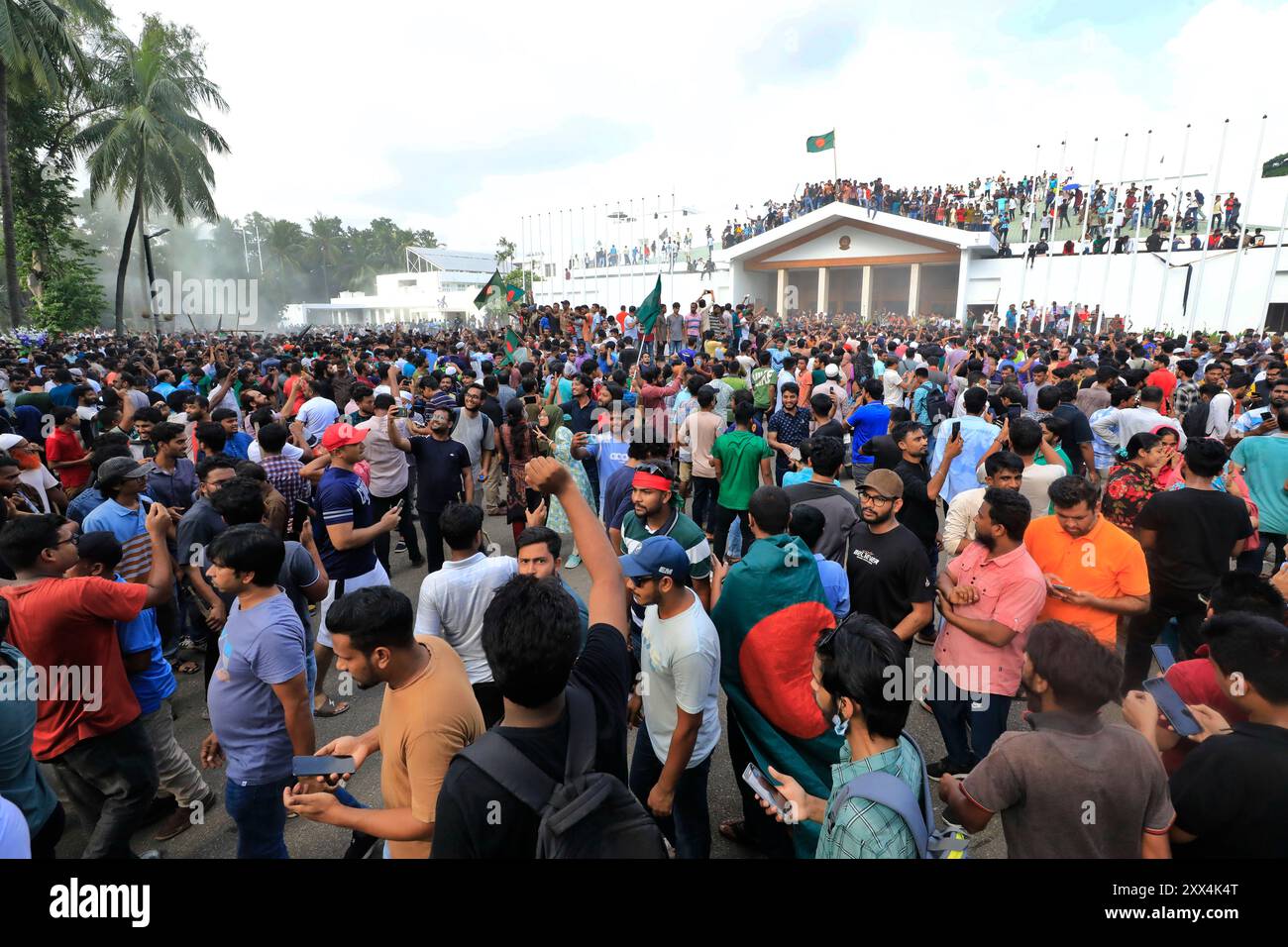 Dhaka, Bangladesch - 05. August 2024: Nach dem Rücktritt von Premierminister Scheich Hasina zeigen Demonstranten der Anti-Regierung Bangladeschs Flagge, während sie stürmen Stockfoto