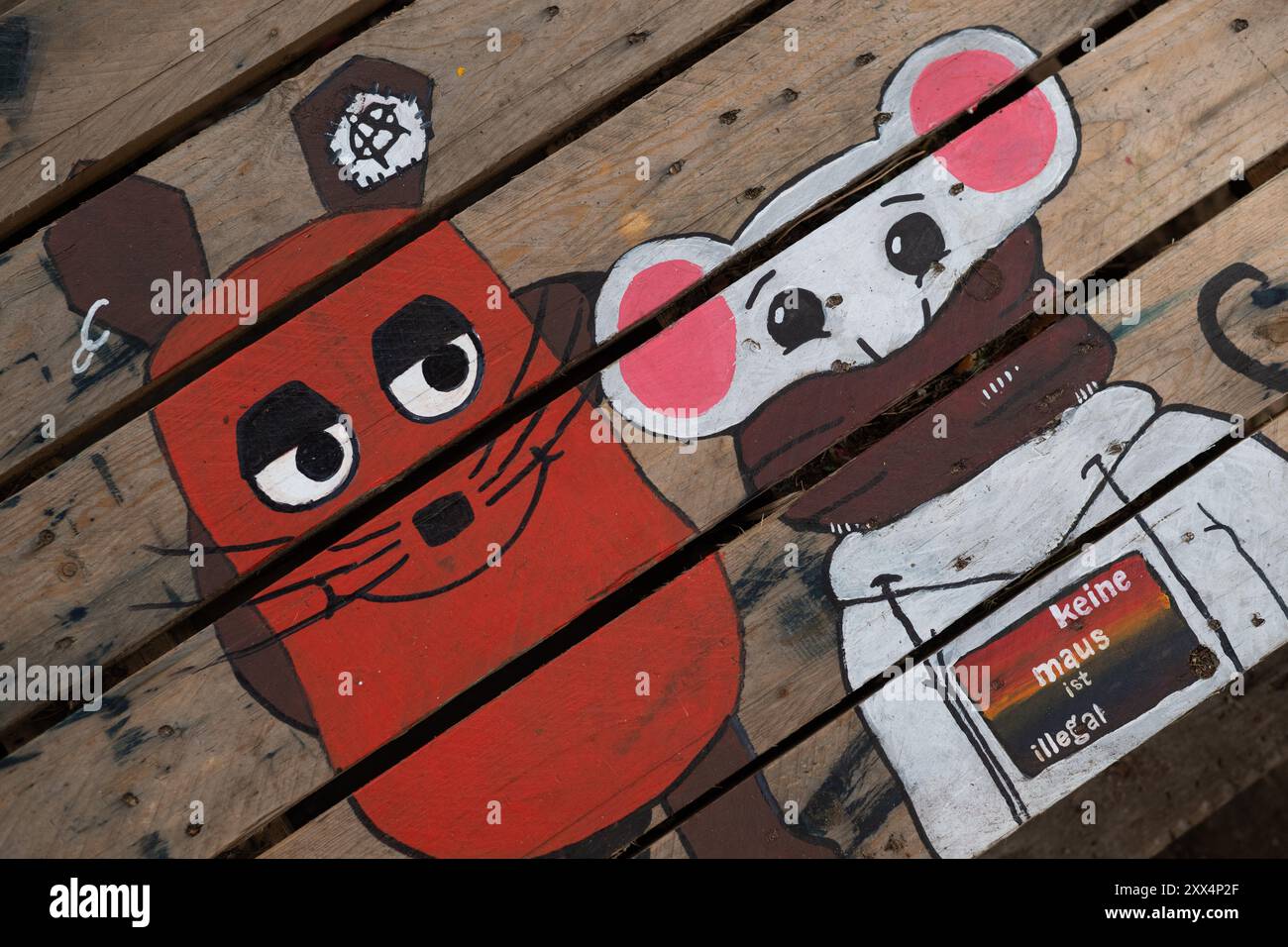 22. August 2024, Brandenburg, Grünheide: Zwei Mäuse werden auf einem Tisch im Protestlager der Tesla-Fabrik der Initiative „Stop Tesla“ gemalt. Eine davon ist die Maus aus der Sendung mit der Maus. Seit Ende Februar besetzen die Aktivisten einen Waldabschnitt neben der Fabrik des Elektroautos. Foto: Sebastian Gollnow/dpa Stockfoto