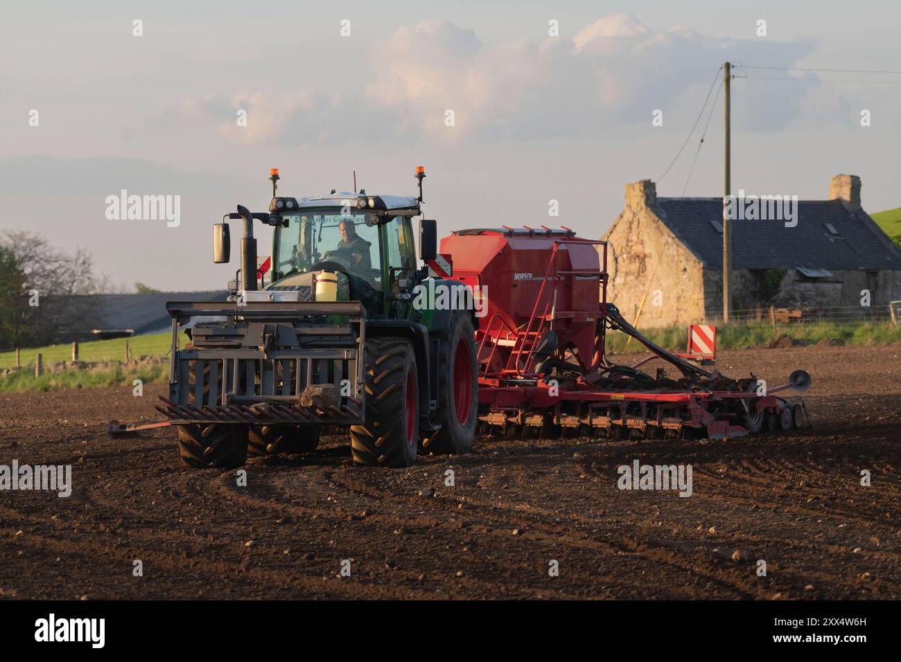 Ein Fendt-Traktor und Horsch-Scheibenbohrer in Evening Sunshine säen ein Feld mit Gerste im Frühjahr Stockfoto