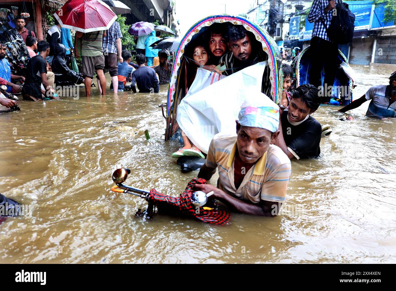 Chittagong, Muradpur, Bangladesch. August 2024. Ein Rikscha-Fahrer zieht Kunden durch tiefes Wasser, das die Straßen von Muradpur in der Stadt Chittagong überschwemmt, nach anhaltendem Regen. 157 mm Niederschlag in Chittagong hat in verschiedenen Teilen der Stadt Wasserabfälle verursacht. Einige Straßen sind für den Verkehr gesperrt. (Kreditbild: © Mohammed Shajahan/ZUMA Press Wire) NUR REDAKTIONELLE VERWENDUNG! Nicht für kommerzielle ZWECKE! Stockfoto