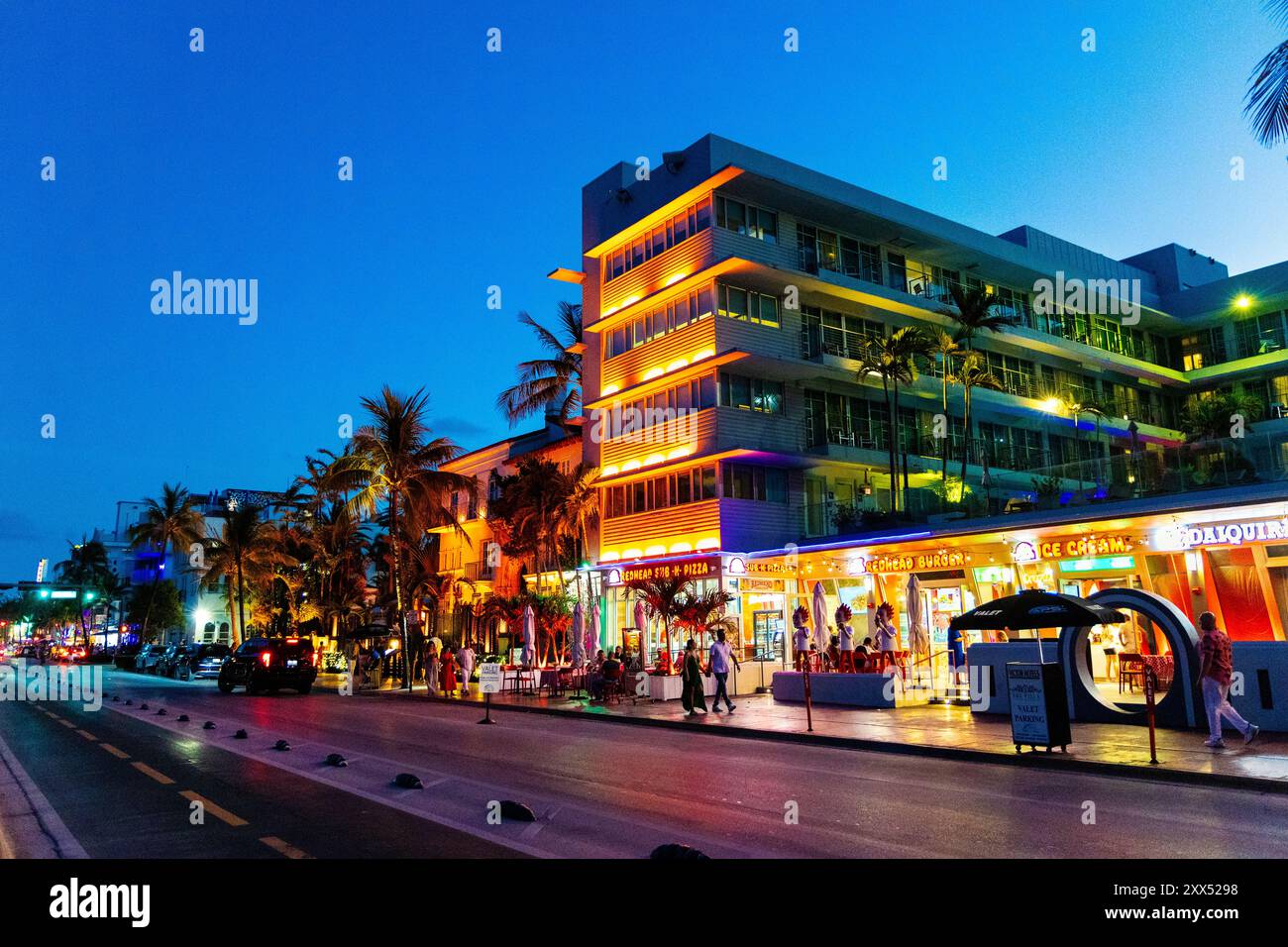 Außenansicht des Hotel Victor, Versace Mansion und beleuchtete Art déco-Gebäude und Restaurants am Ocean Drive, Miami Beach, Florida, USA Stockfoto