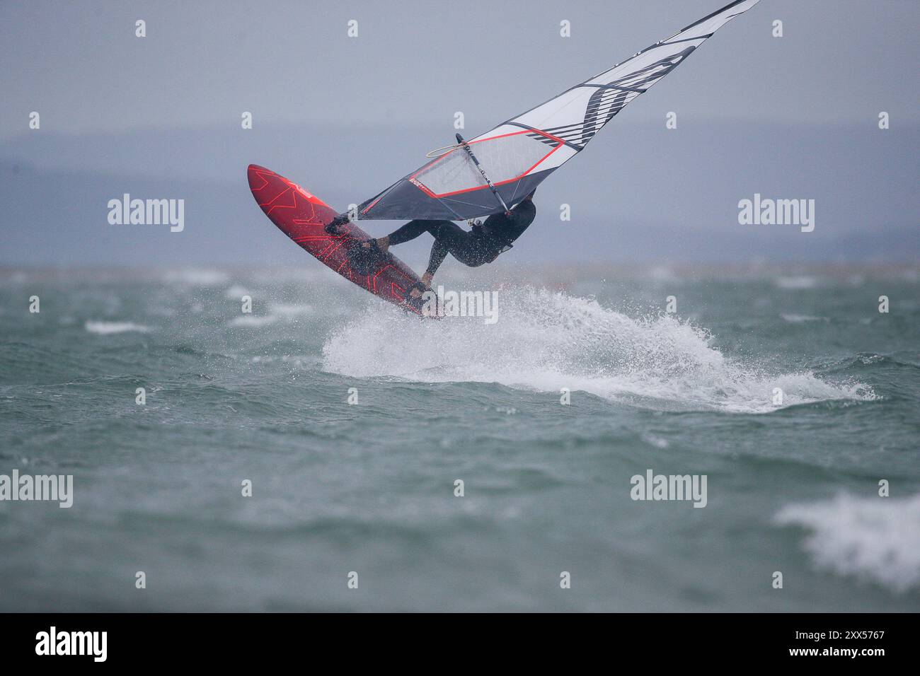 Beachlands, Hayling Island. August 2024. Starke Winde und zeitweilige Regenfälle für die Südküste heute, als Ex-Hurrikan Ernesto an Land kam. Windsurfer genießen die anspruchsvollen Bedingungen auf Beachlands, Hayling Island in Hampshire. Quelle: james jagger/Alamy Live News Stockfoto