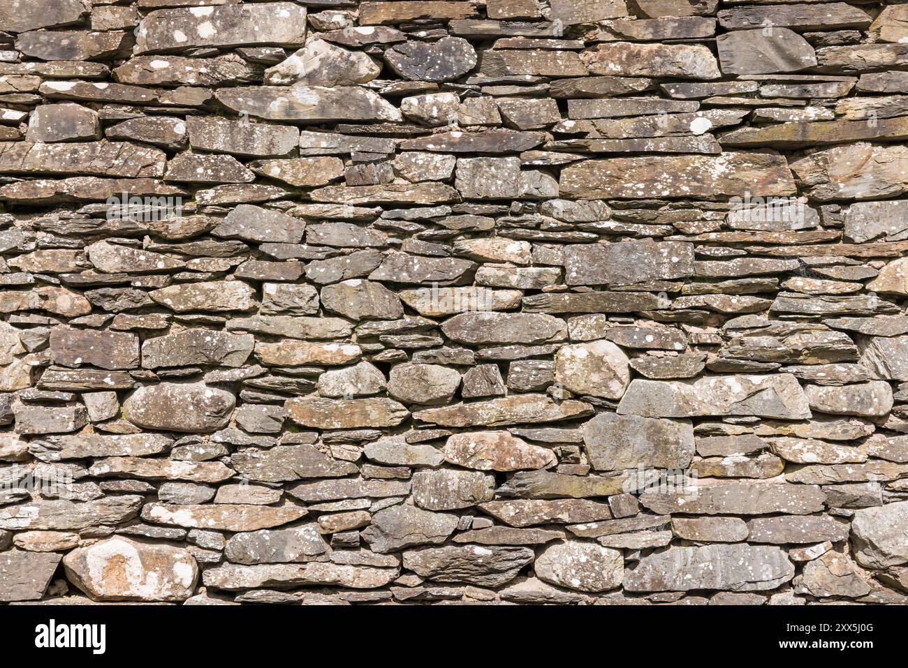 Detail einer Trockenmauer an einem alten Gebäude im englischen Lake District, Großbritannien. Vollbild-Muster, Textur oder Hintergrund. Stockfoto
