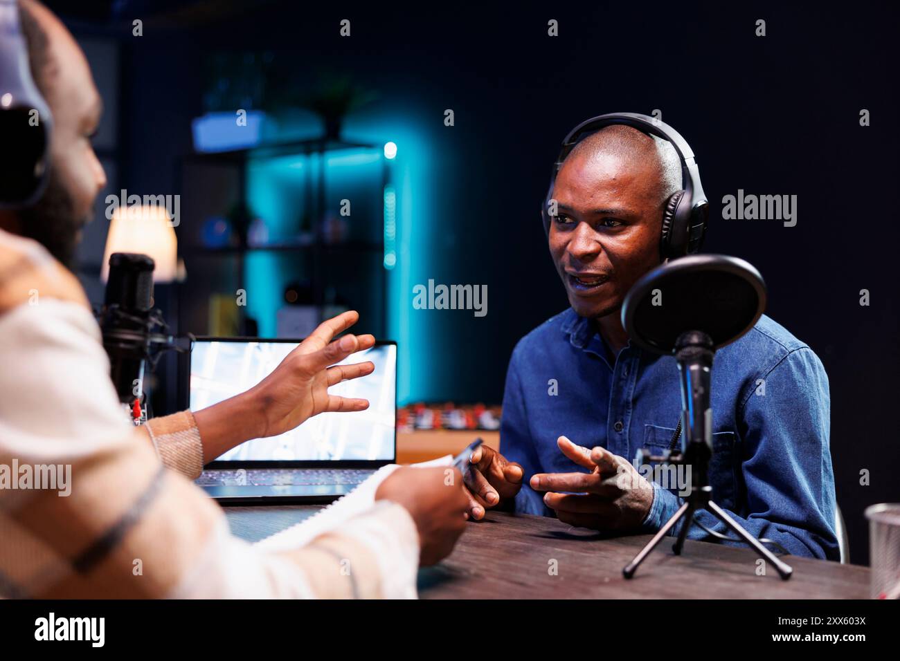 Der Moderator der Black man-Radiosendung hält Live-Chat mit Gästen und zeichnet die Interaktion auf, damit das Publikum live hören kann. Influencer spricht mit Journalisten und sendet die Debatte an Online-Fans zu Hause. Stockfoto