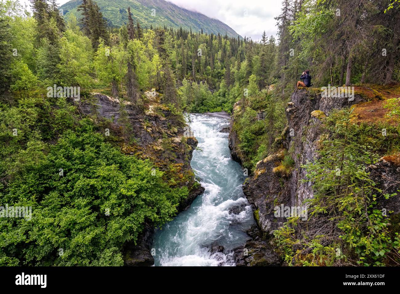 Person auf der Klippe oberhalb des Six Mile Creek im Chugach National Forest auf der Kenai Peninsula, in der Nähe von Hope, Alaska Stockfoto