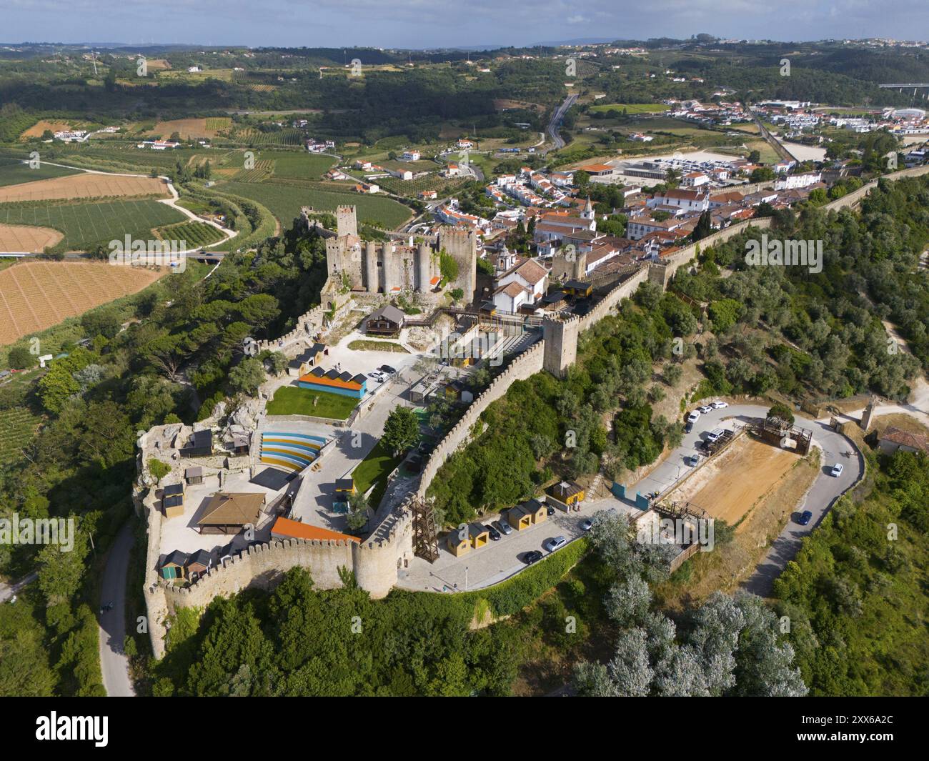 Aus der Vogelperspektive auf eine große Burg und Festung umgeben von Bäumen und Ackerland mit historischer Architektur und Verteidigungsanlagen, Stadt, Burg, Castelo de Obid Stockfoto