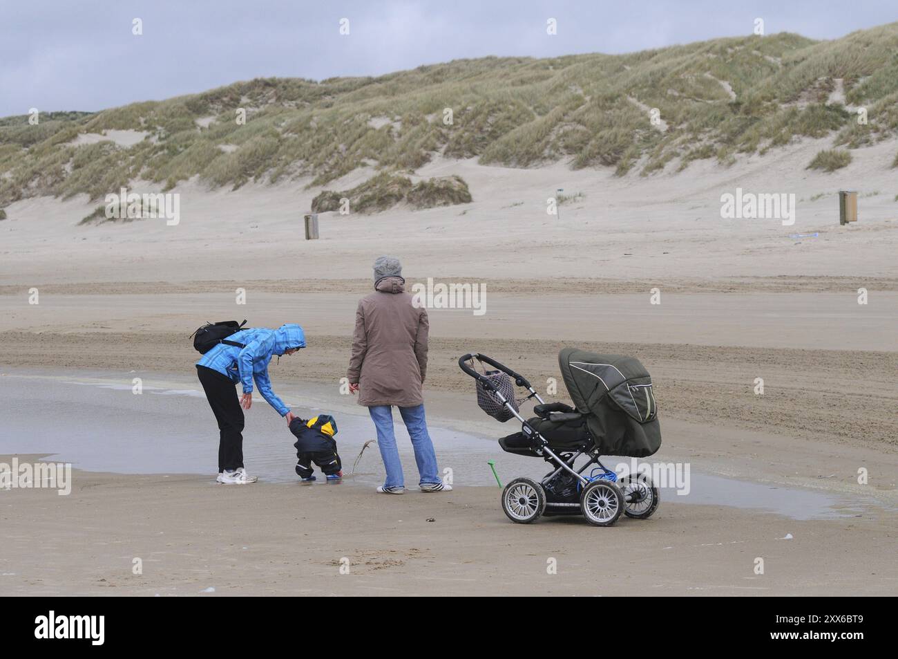 Familie besucht den Sandstrand an einem windigen Tag im Frühjahr in Blokhus, Jütland, Dänemark, Skandinavien, Europa Stockfoto