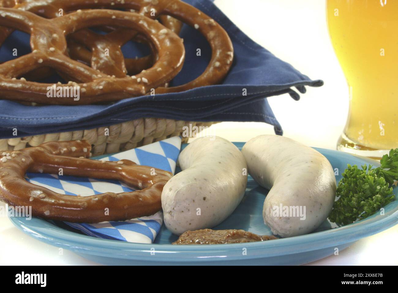 Weißwurst mit süßem Senf und Brezeln vor weißem Hintergrund Stockfoto