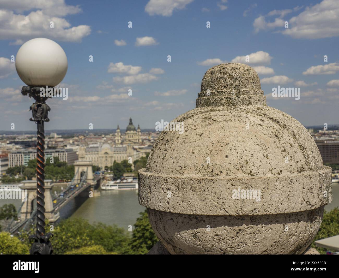 Steinschmuck und Straßenlaterne mit Blick auf die Stadt und den Fluss unter einem leicht bewölkten Himmel, budapest, donau, ungarn Stockfoto