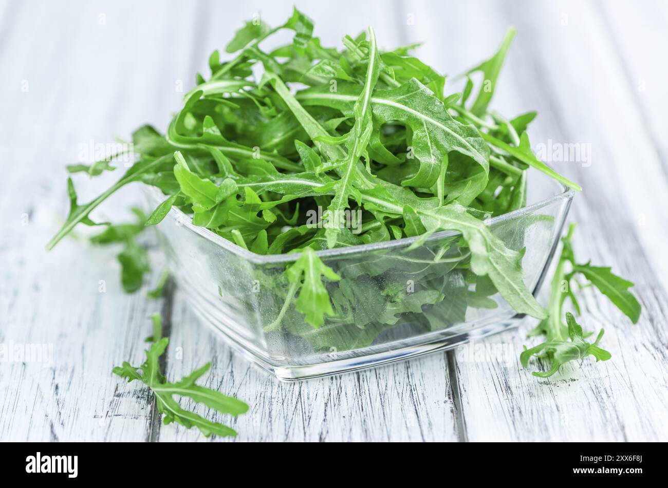 Holztisch mit frischem Arugula als detaillierte Nahaufnahme (selektiver Fokus) Stockfoto