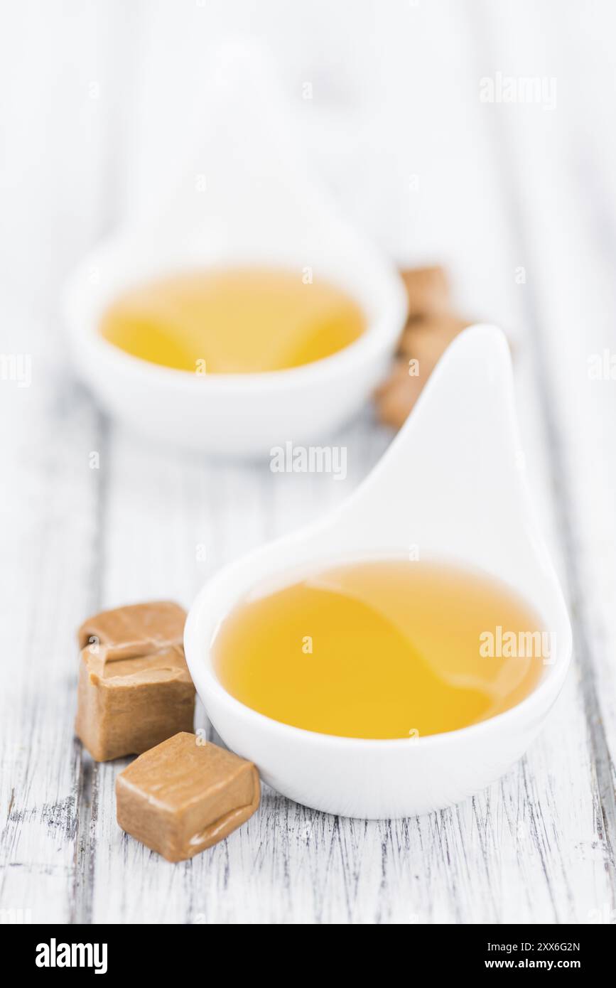 Karamell-Sirup als hoch detaillierte Nahaufnahme auf einem Vintage Holztisch (Tiefenschärfe) Stockfoto