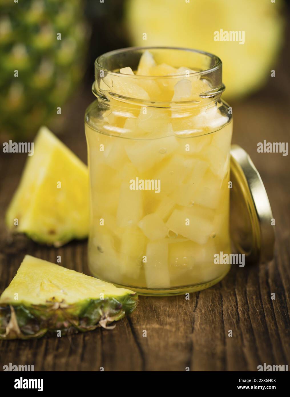 Gehackte Ananas (konserviert) als detailreiche Nahaufnahme auf einem Vintage Holztisch, selektiver Fokus Stockfoto