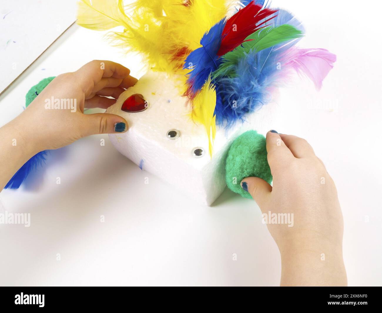 Kleine Mädchen Hände spielen mit bunten Federn, Oster-Deko zu schaffen Stockfoto