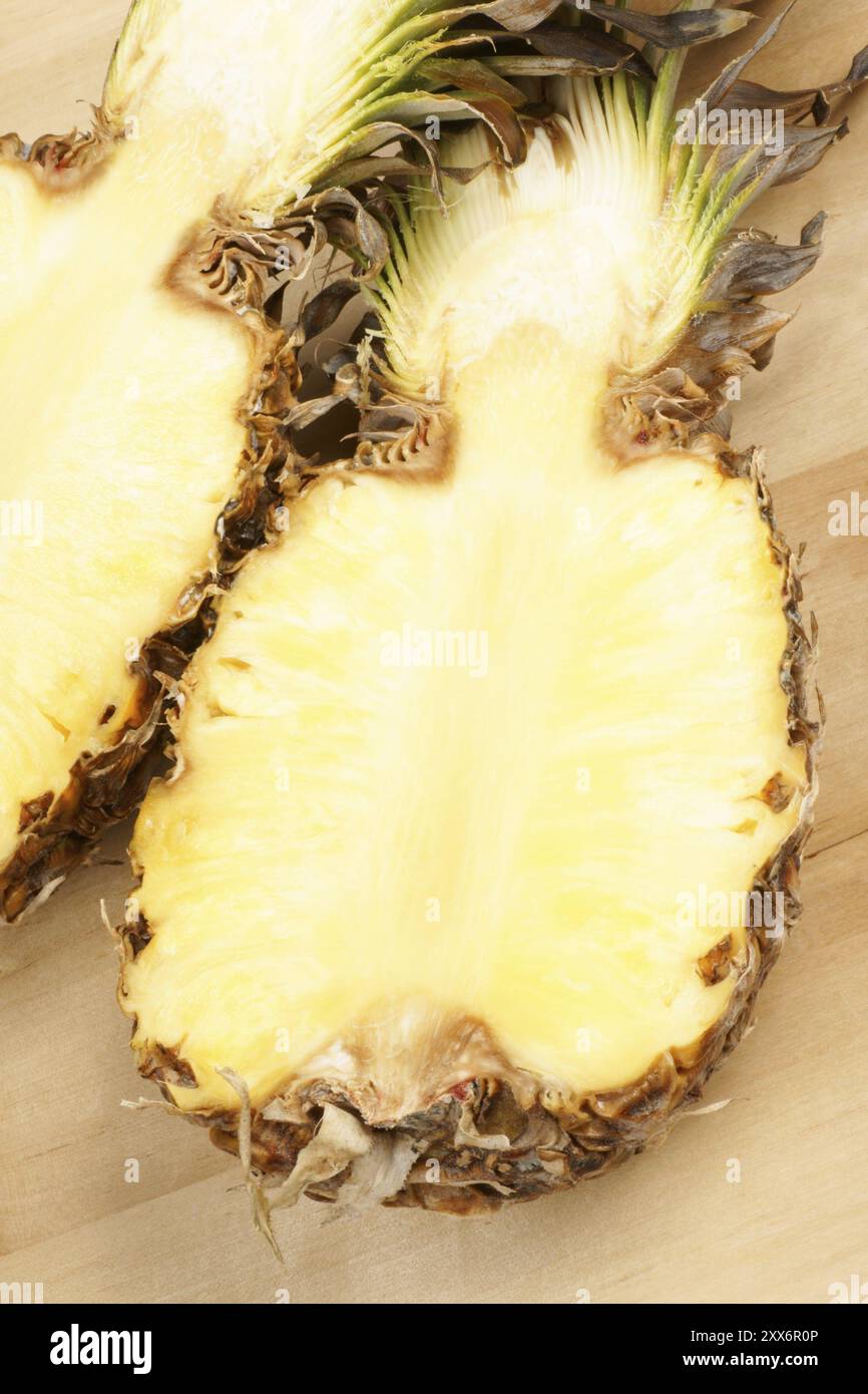 Frische, halb geschnittene Ananas auf hölzernem Hintergrund Stockfoto