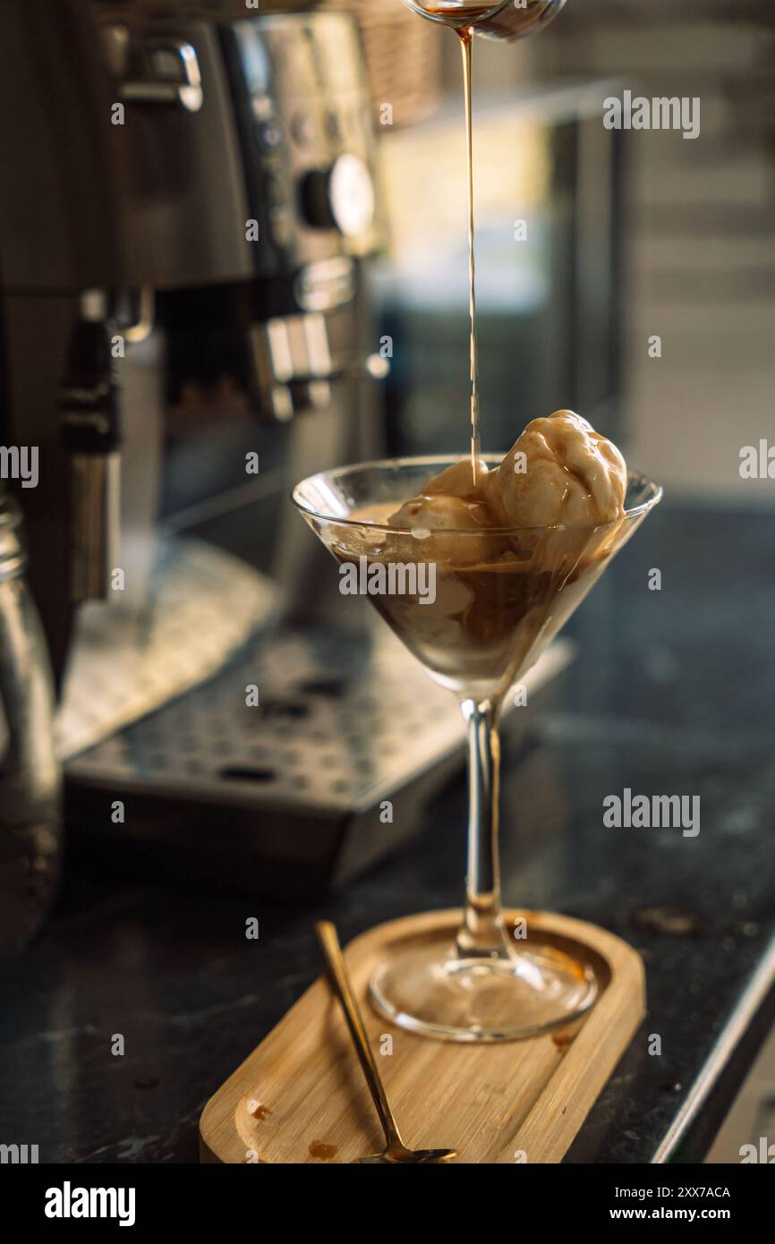 Das Kaffeeis wird vor der Kaffeemaschine mit Zuckersirup getränkt. Stockfoto
