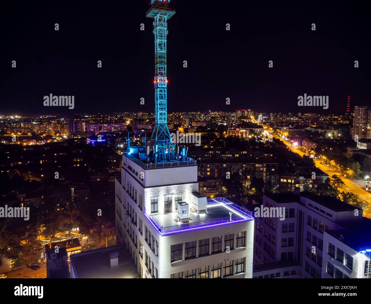 Nächtlicher Blick auf das Dach des Derzhprom-Gebäudes mit beleuchteter Stadt Charkiw, Ukraine Stockfoto