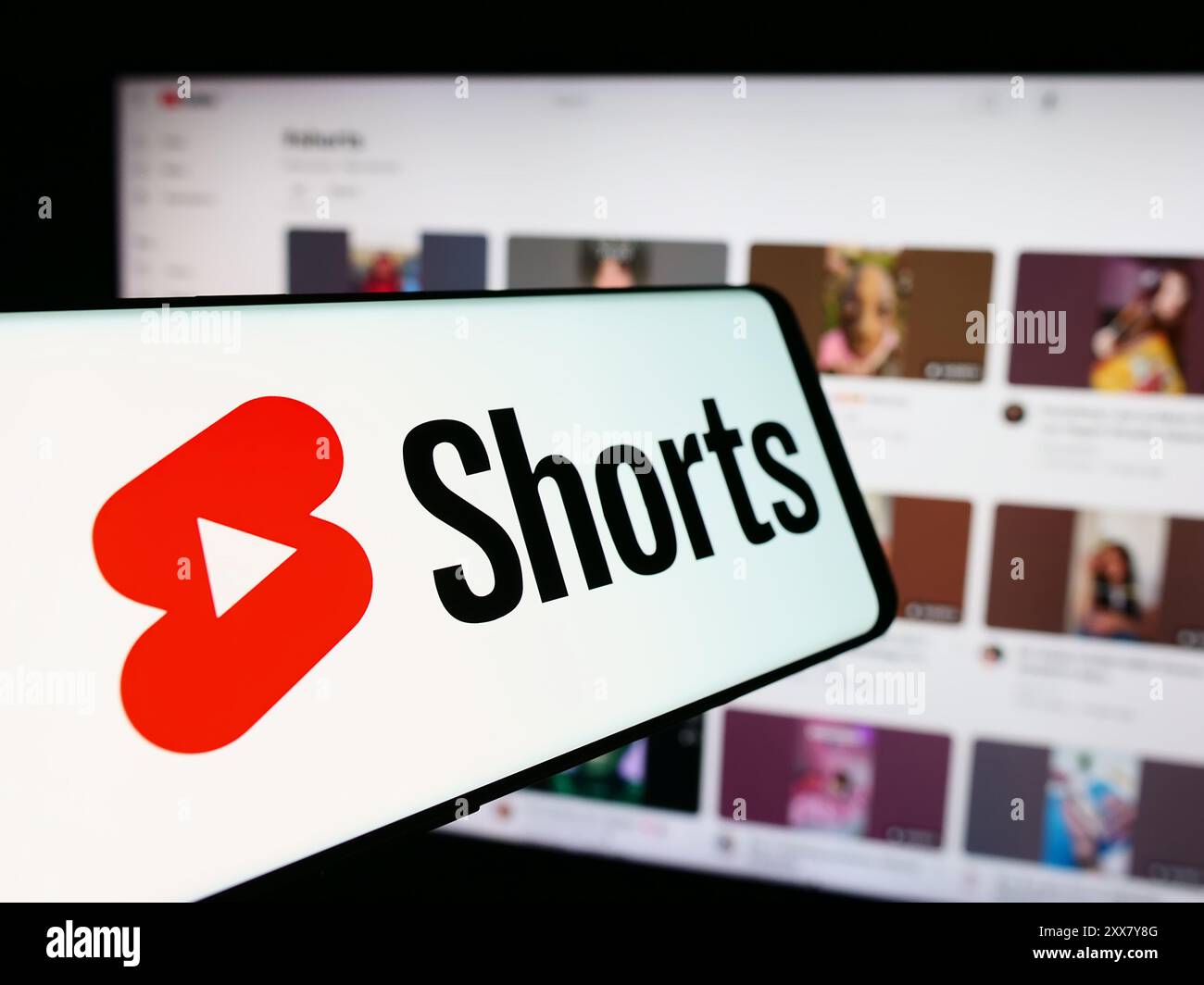 Mobiltelefon mit Logo des kurzen Video-Sharing-Dienstes YouTube Shorts vor der Business-Website. Fokussieren Sie sich auf die linke Mitte des Telefondisplays. Stockfoto