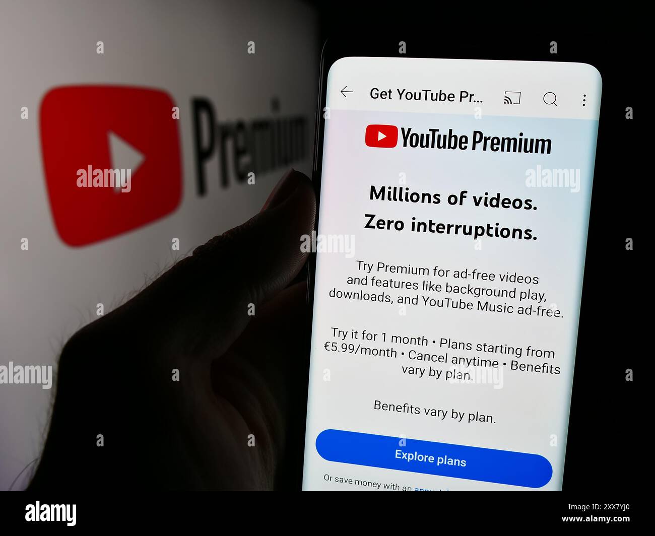 Person, die ein Smartphone hält und die Webseite des Video-Streaming-Abonnementdienstes YouTube Premium vor dem Logo zeigt. Konzentrieren Sie sich auf die Mitte des Telefondisplays. Stockfoto