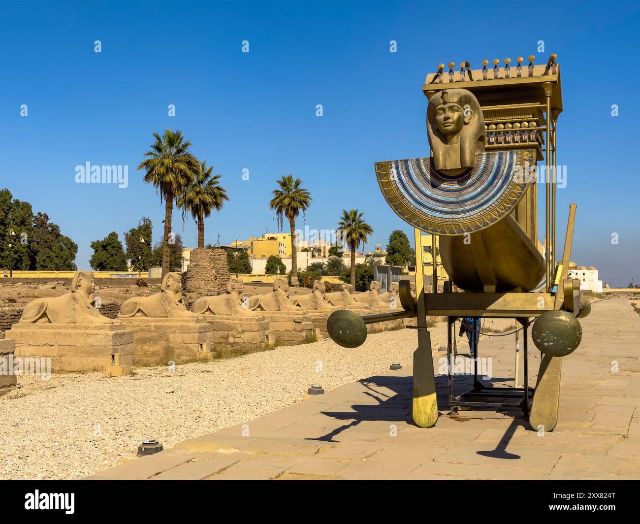 Ein Solarboot gleitet majestätisch die Avenida der Sphinxes hinunter und verbindet die antiken Tempel von Luxor und Karnak in Theben. Stockfoto