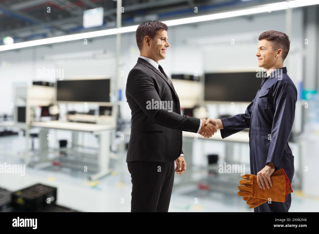 Manager schüttelt Hand mit einem Arbeiter in einer Fabrik Stockfoto