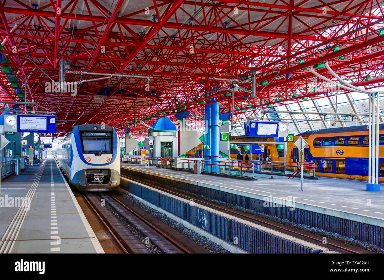 Lelystad, Niederlande, 4. August 2024: Bahnsteige und Züge unter dem charakteristischen roten Raumrahmenbau des städtischen Bahnhofs Stockfoto