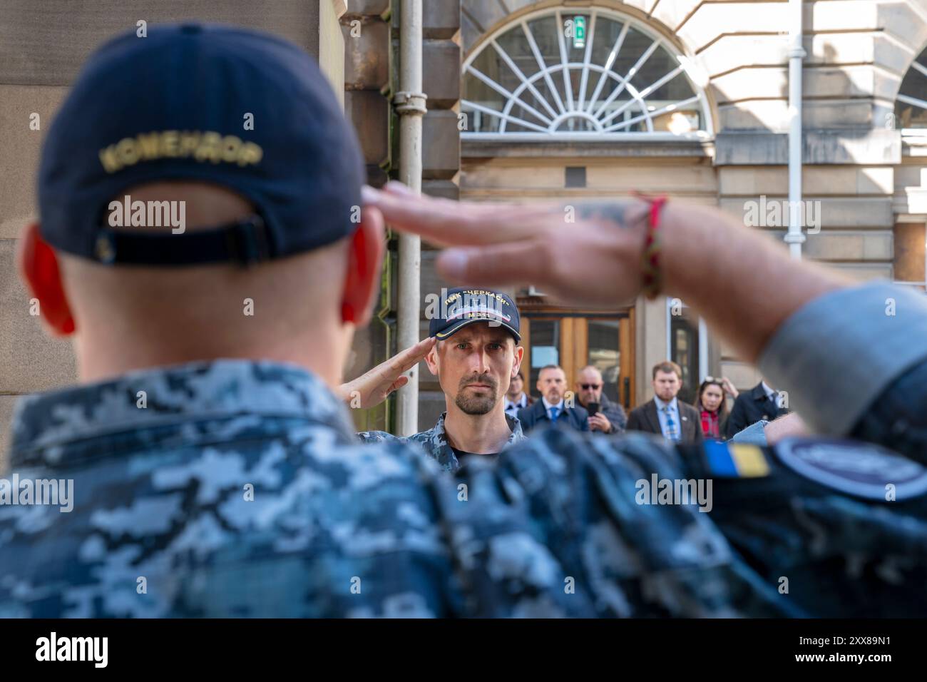 Mitglieder des ukrainischen Militärs grüßen vor den Stadtkammern von Edinburgh während einer Zeremonie zum Unabhängigkeitstag der Ukraine, die am 24. August stattfindet. Mitglieder der ukrainischen Gemeinschaft kommen zusammen, um der Toten des jüngsten Konflikts zu gedenken und auch den Jahrestag der Unterzeichnung der Unabhängigkeitserklärung im Jahr 1991 zu feiern. Bilddatum: Freitag, 23. August 2024. Stockfoto